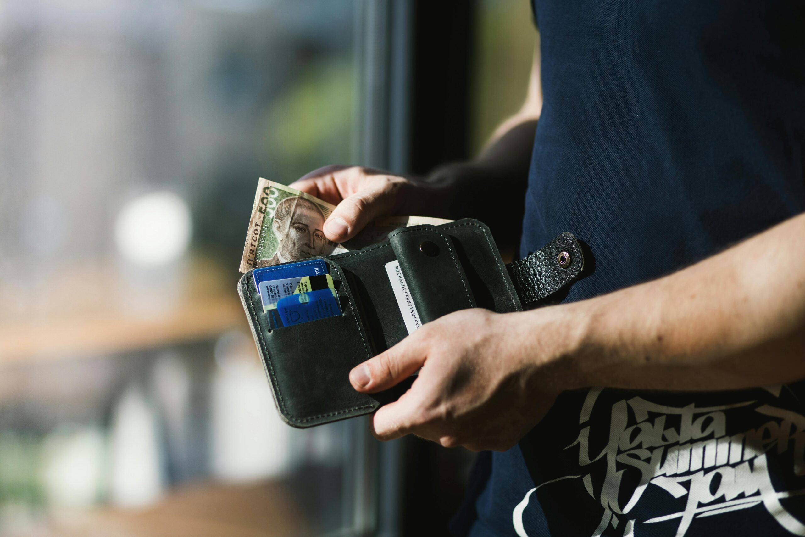 a man holding a wallter with money inisde